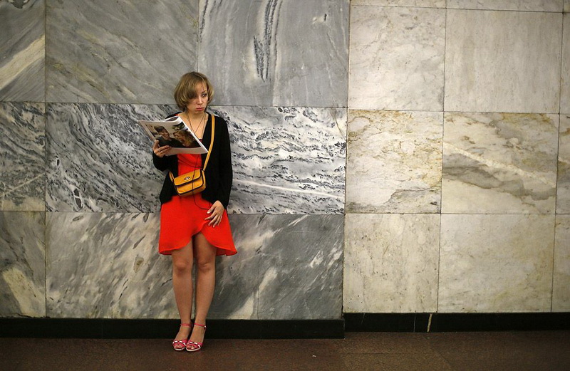 A woman reads a magazine in Chistye Prudy metro station in Moscow